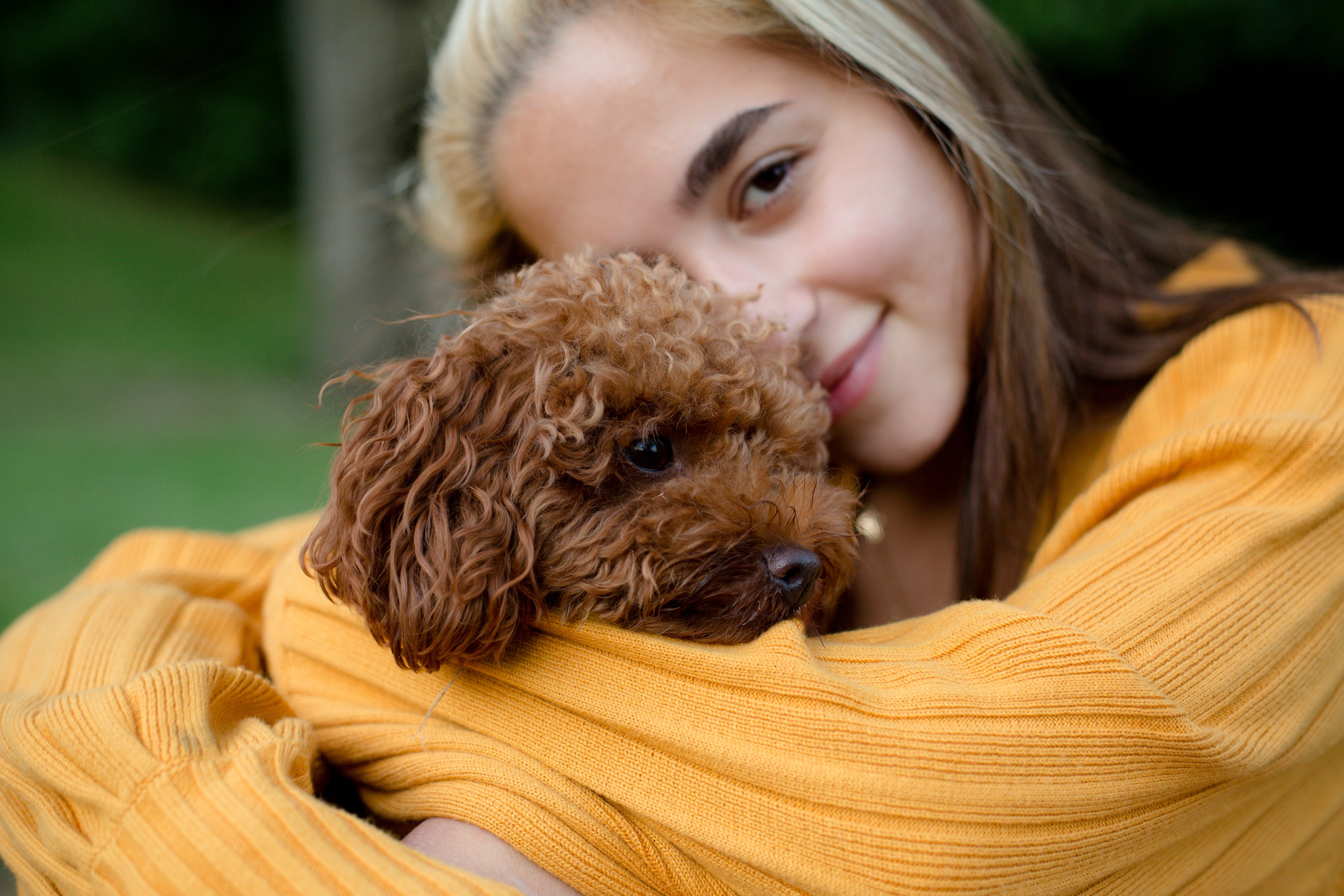 files/a-woman-hugs-a-small-brown-puppy-outdoors.jpg