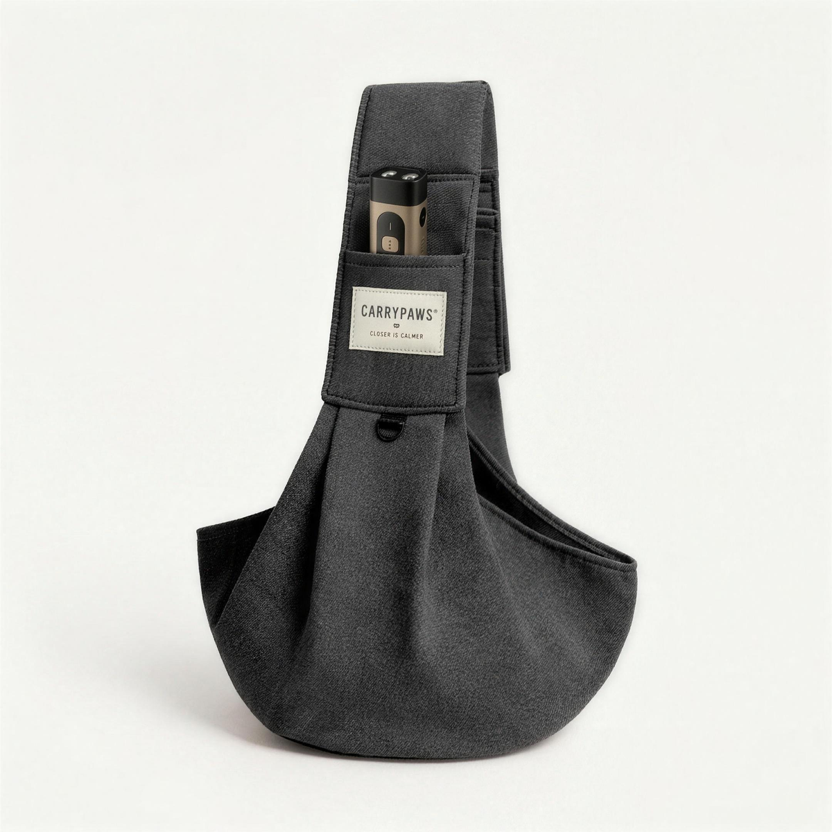 Dark grey CarryPaws™ dog sling carrier with the brown QuietPaws™ bark control device in its front pocket