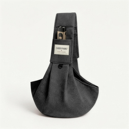 Dark grey CarryPaws™ dog sling carrier with the brown QuietPaws™ bark control device in its front pocket
