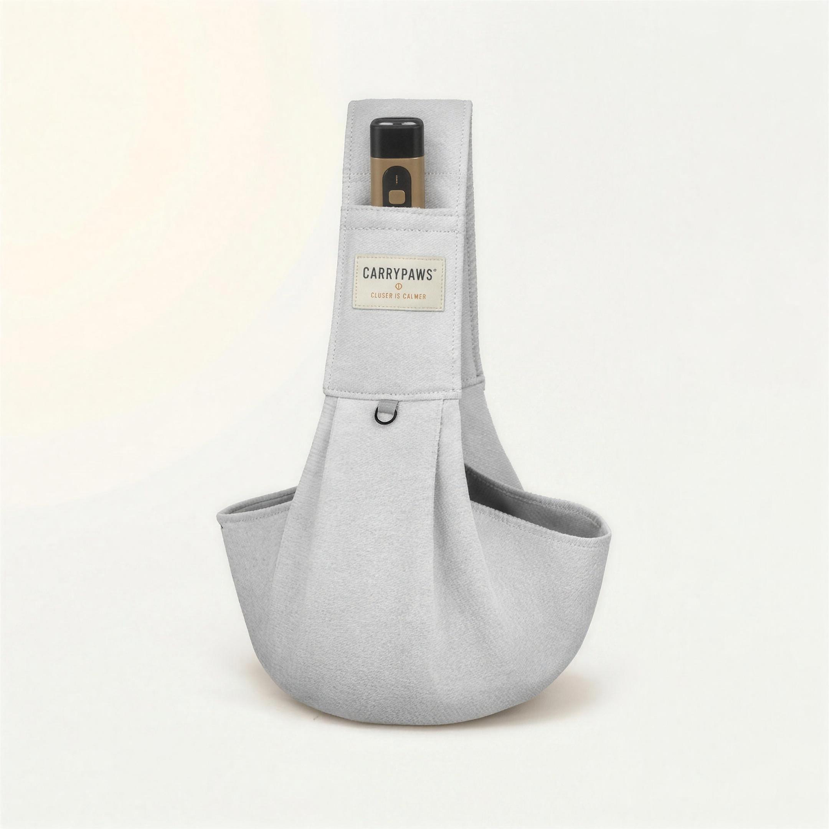 Light grey CarryPaws™ dog sling carrier with the brown QuietPaws™ bark control device in its front pocket